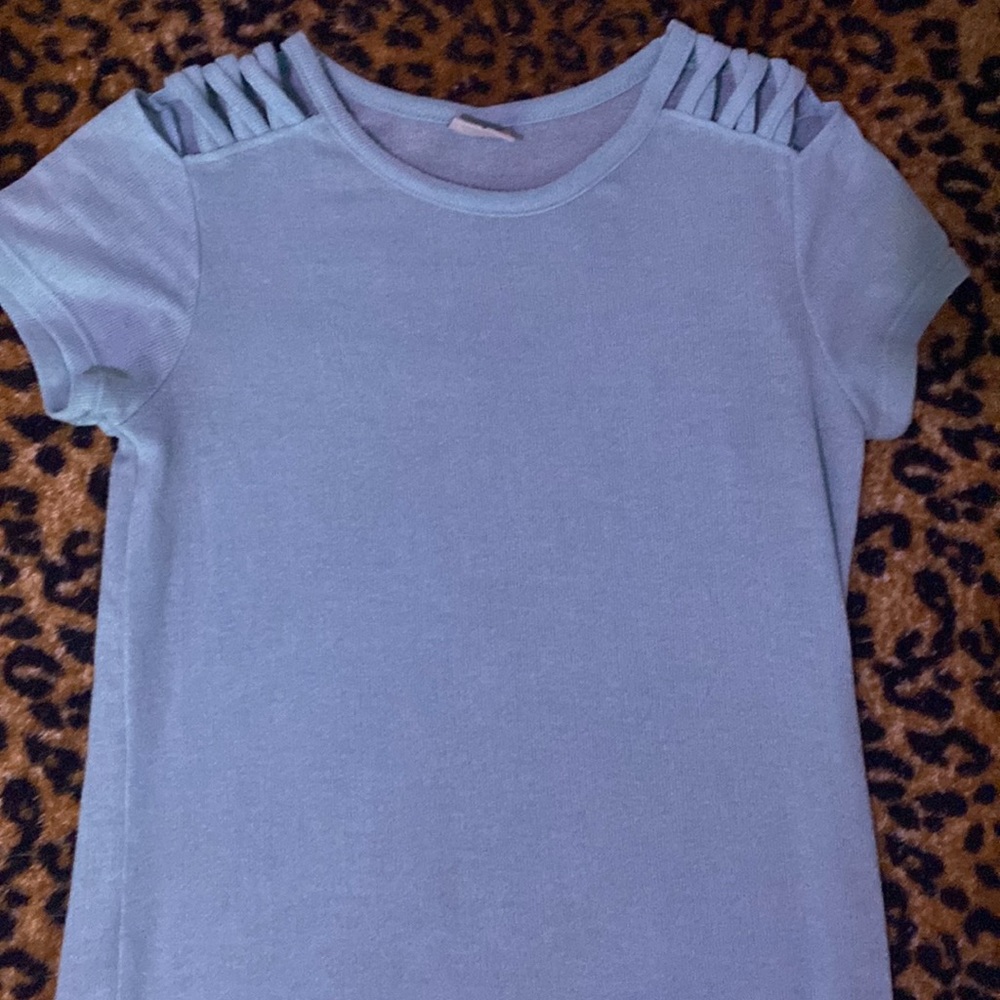 It’s a light blue shirt with cutouts at the sholder